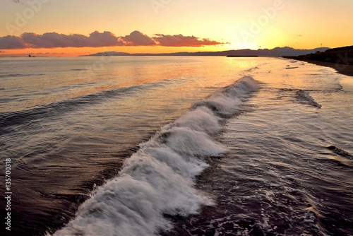 夕焼けの茜色と砕ける波の白さ 夕焼けの中で波打ち際の波が様々に形を変えていく様子が興味深い Stock Photo Adobe Stock