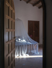Son Vent Architect’s Family Home In Mallorca Bedroom With Mosquito Net And Open Door.