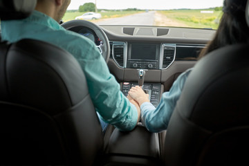 Wall Mural - happy couple driving in car and holding hands