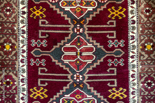 Fotografering Edges and central part with folk eastern ornament on woolen carpet in burgundy b
