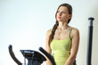 © aleksandr_yu - Young beautiful white girl in a yellow and gray sports suit is engaged on a stationary bike in the fitness club.