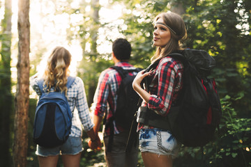 Wall Mural - group of backpacking hikers going for forest trekking