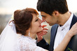 © myronovychoksana - Groom's tender hands touch bride's face while she smiles to him
