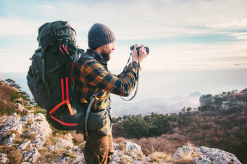 Wall Mural - Man photographer with backpack and camera taking photo of mountains Travel Lifestyle hobby concept adventure vacations outdoor