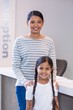 © WavebreakMediaMicro - Portrait of smiling mother and daughter standing at counter