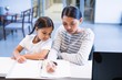 © WavebreakMediaMicro - Mother and daughter filling out paperwork at counter