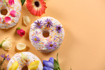 Wall Mural - Delicious donuts and flowers on peach colour background