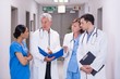 © WavebreakMediaMicro - Nurse and doctors discussing over clipboard