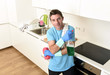 © Wordley Calvo Stock - young happy man holding washing detergent spray bottle and sponge in gloves smiling confident