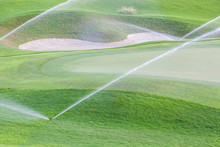 Sprinklers Watering System Working In Green Golf Course.