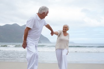 Wall Mural - Senior couple having fun together at beach