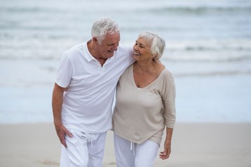 Wall Mural - Senior couple embracing each other on the beach
