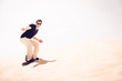 © nullplus - Tourist Sandboarding In The Desert