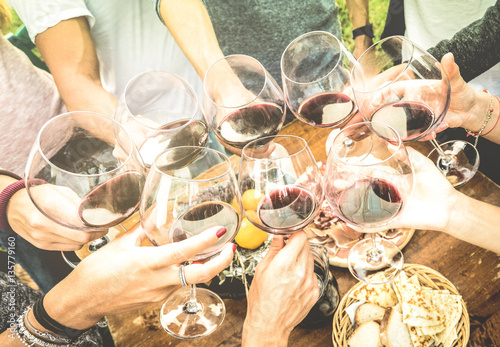 Cuadros en Lienzo Friends hands toasting red wine glass and having fun outdoors cheering with wine