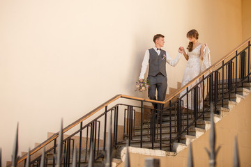 Bride and groom walking on stairs of castle after wedding ceremony