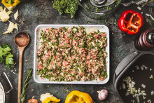 Meat Stuffing With Ground Meat, Rice And Chopped Kale For Paprika Filling  On Rustic  Kitchen Table Background With Wooden Cooking Spoon, Pot And Vegetables Ingredients, Top View