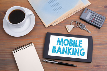 Wall Mural - Mobile banking, business concept. Text on tablet device on a wooden table.
