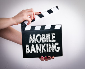Wall Mural - Mobile banking concept. Female hands holding movie clapper. 