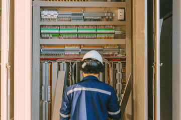 Instrument technician on the job check wiring on PLC cabinet