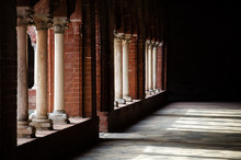 Light And Shadows Over The Colonnade Of A Romanesque Cloister In An Italian Medieval Abbey