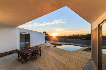 Chairs in modern house with wooden deck