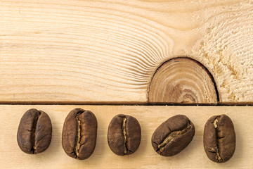 Wall Mural - Brown coffee beans on yellow textured wooden board background cl