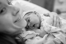 Mother Holding Newborn Baby Girl In The Hospital