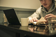 © e-stock - カフェで勉強・仕事をする男性