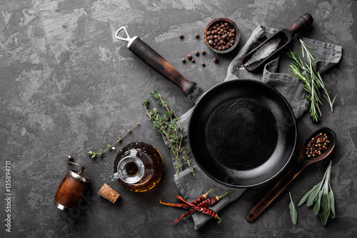Fotomural dark culinary background with empty black pan and space for text recipe or menu