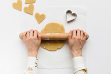 Woman Rolling Out Sweet Dough To Make Heart Shaped Biscuits