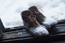Vintage Leather Shoes Covered In Snow By The Door