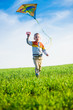 © mr.markin - Young boy flies his kite in an open field. Little kid playing with kite on green meadow. Childhood concept.