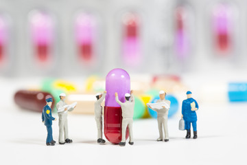 miniature people on the drugs or pils on white,medical concept