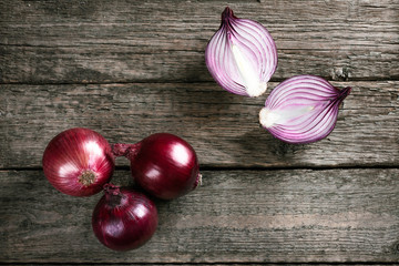 Fresh organic red onions on a wooden background