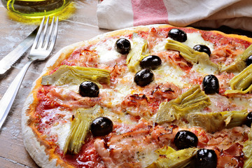 Wall Mural - Pizza with tomato, mozzarella, artichokes, cooked ham and olives