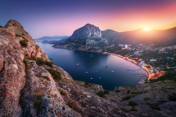 Wall Mural - View from the mountain peak on the city, blue sea and high rocks against beautiful sky at sunset. Colorful mountain landscape in the evening. Vacation on seashore. Summer travel in Europe. City lights