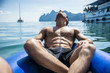 © theartofphoto - Rear view of a man on a raft relaxing drifting along the river in Phuket, Thailand