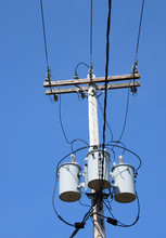 Three Transformers On A Power Pole With Wires