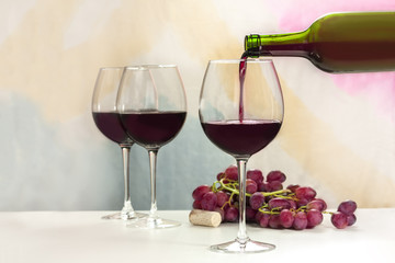 Wall Mural - Photo of red wine poured into glass from bottle