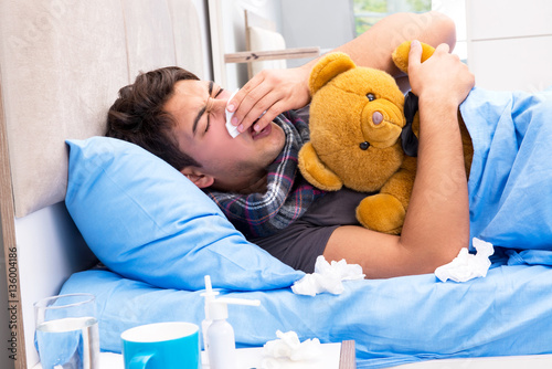 Fotografia Sick man with flu lying in the bed