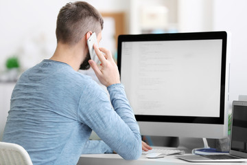 Handsome young programmer working in office