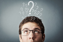 Thinking Teen With Many Question Marks Above His Head