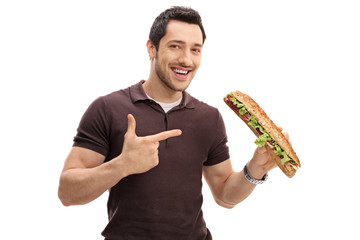 Wall Mural - Young man holding a sandwich and pointing