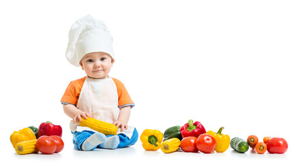 Wall Mural - Smiling chef kid boy with vegetables isolated on white background