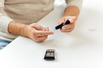 Wall Mural - senior man with glucometer checking blood sugar