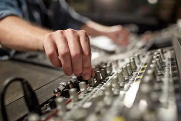 man using mixing console in music recording studio