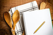 Receta cuaderno de cocina con lápiz y cucharas de madera. vista superior