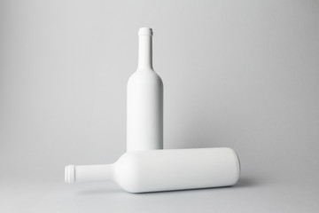 Two wine bottles are standing on gray background