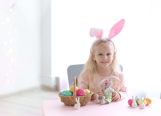 Wall Mural - Cute funny girl with bunny ears, Easter eggs and toy at home