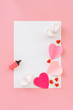 white sheet of paper and a pink marker on a pink paper background with paper hearts stickers and candy. background paper on the topic of love. bright background for an inscription.